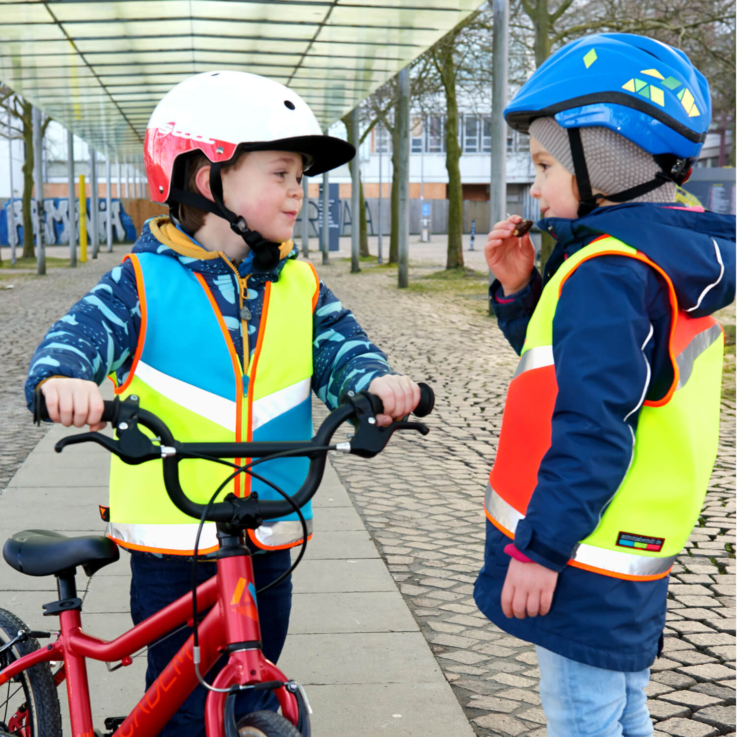 Junge und Mädchen mit Kinderwarnwesten & Fahrrad