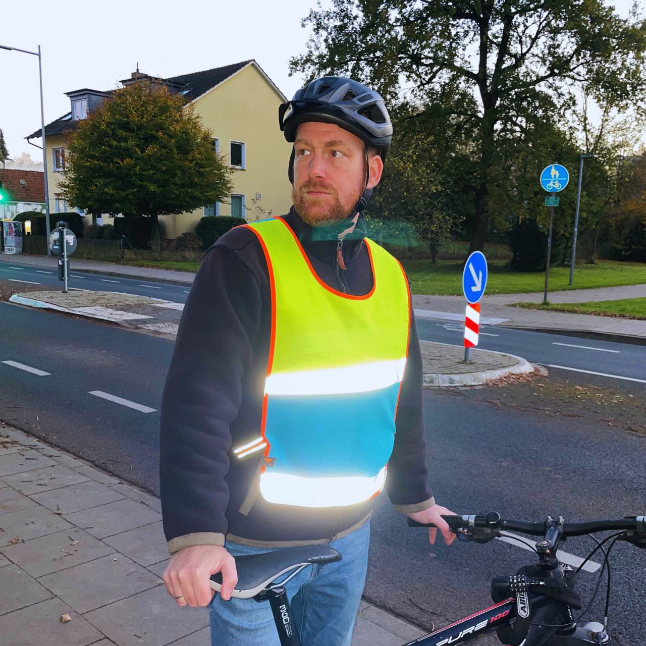 Fahrradfahrer mit reflektierendem Überwurf in gelb-blau