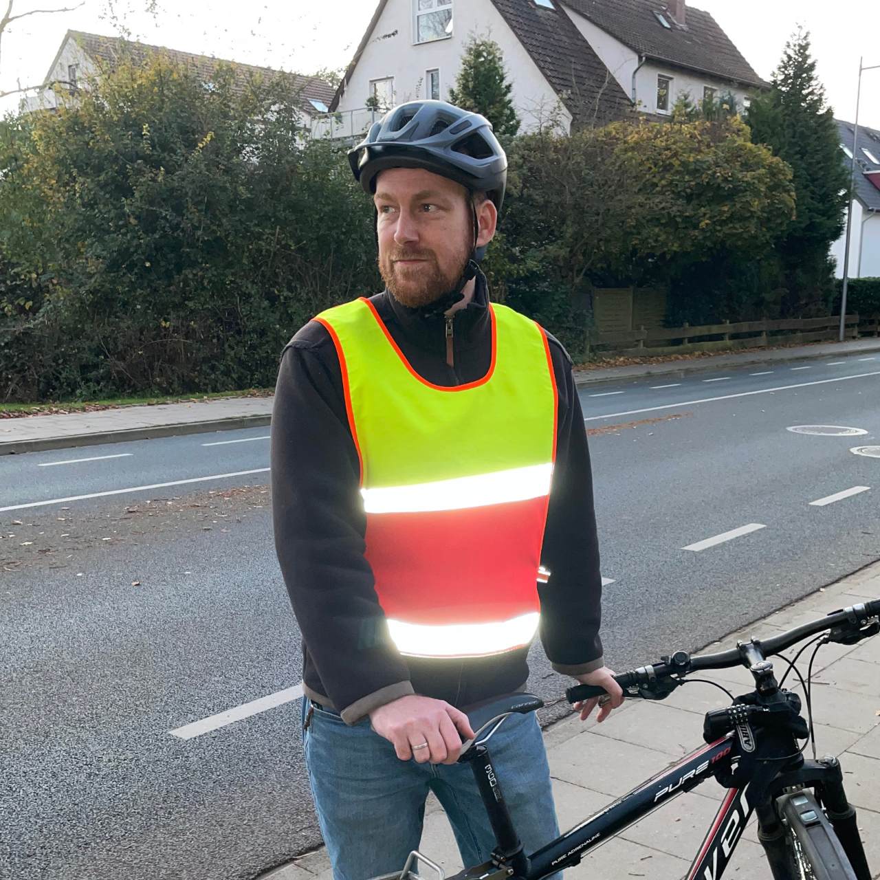 Fahrradfahrer mit reflektierendem Überwurf in gelb-rot