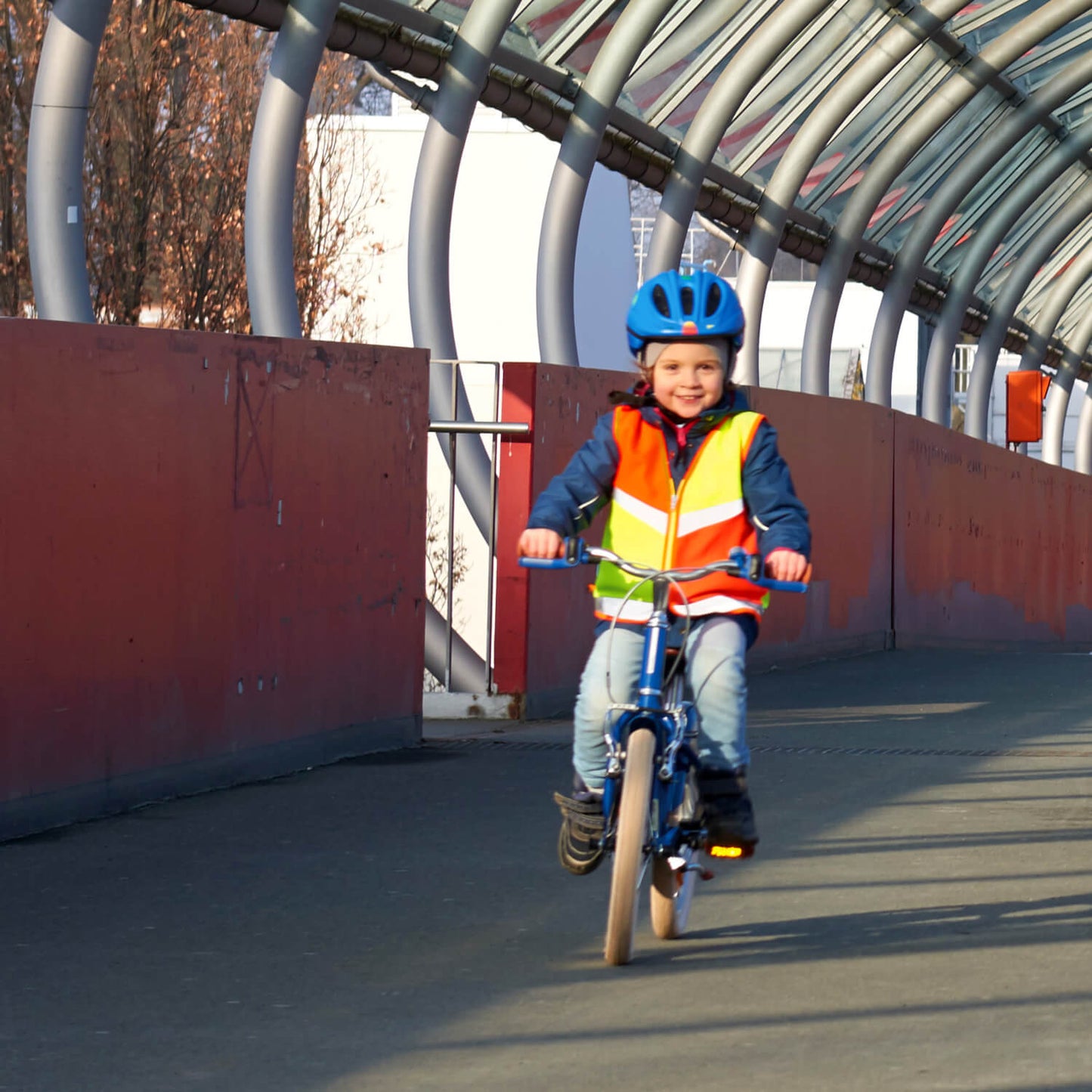 Mädchen mit Kinderwarnweste auf dem Fahrrad