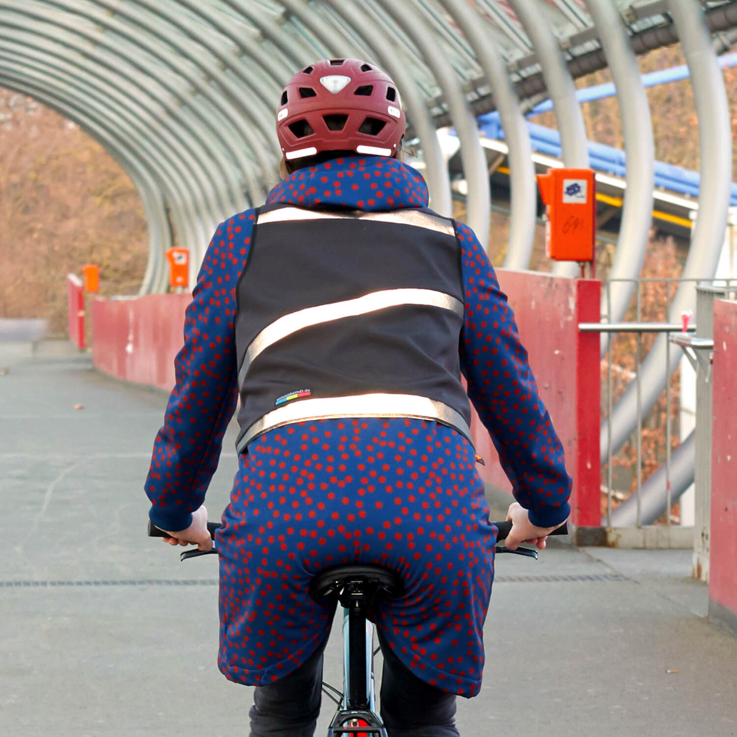 Radfahrerin von hinten mit schwarzer Warnweste